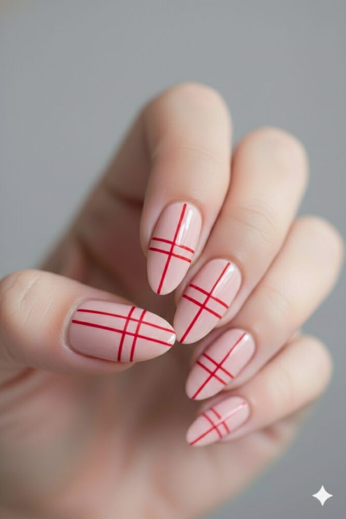 Modern valentines nails with a pink base and clean straight red lines crossing over.