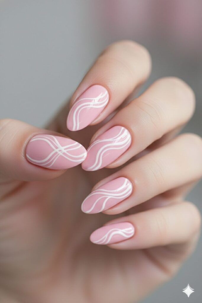 Soft pink valentines nails featuring abstract white swirl lines for a modern feminine look.