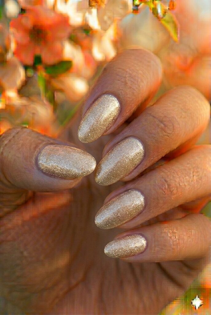 Champagne shimmer spring nails with elegant sparkly champagne gold shade on oval nails, luxurious festive manicure for spring 2026