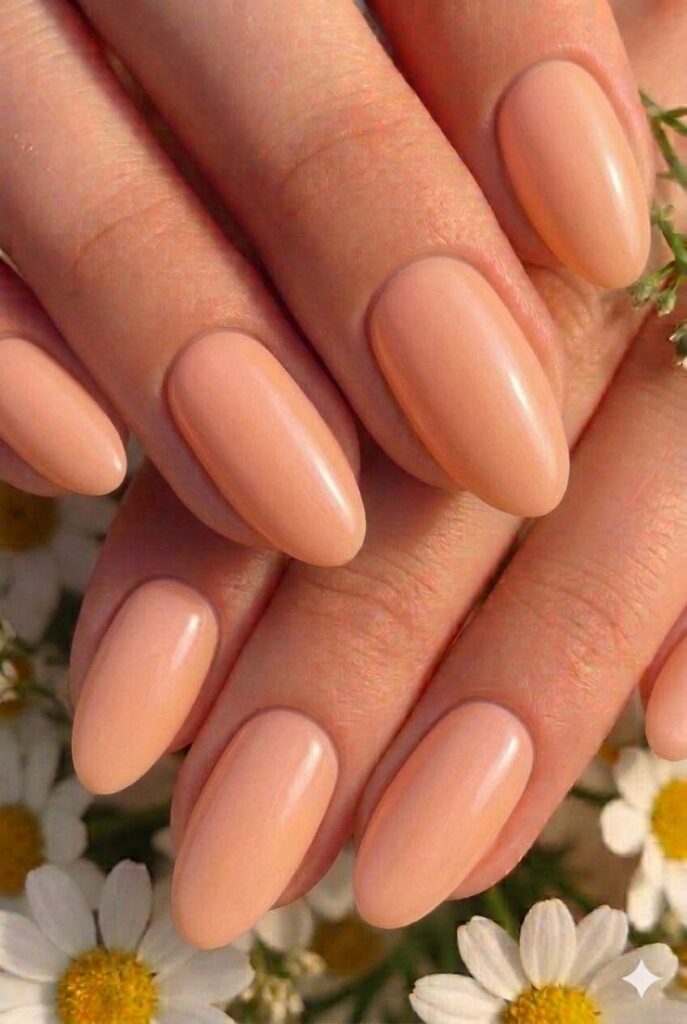 Soft apricot pastel Easter nails with warm gentle orange-pink glowing shade, radiant spring manicure 2026
