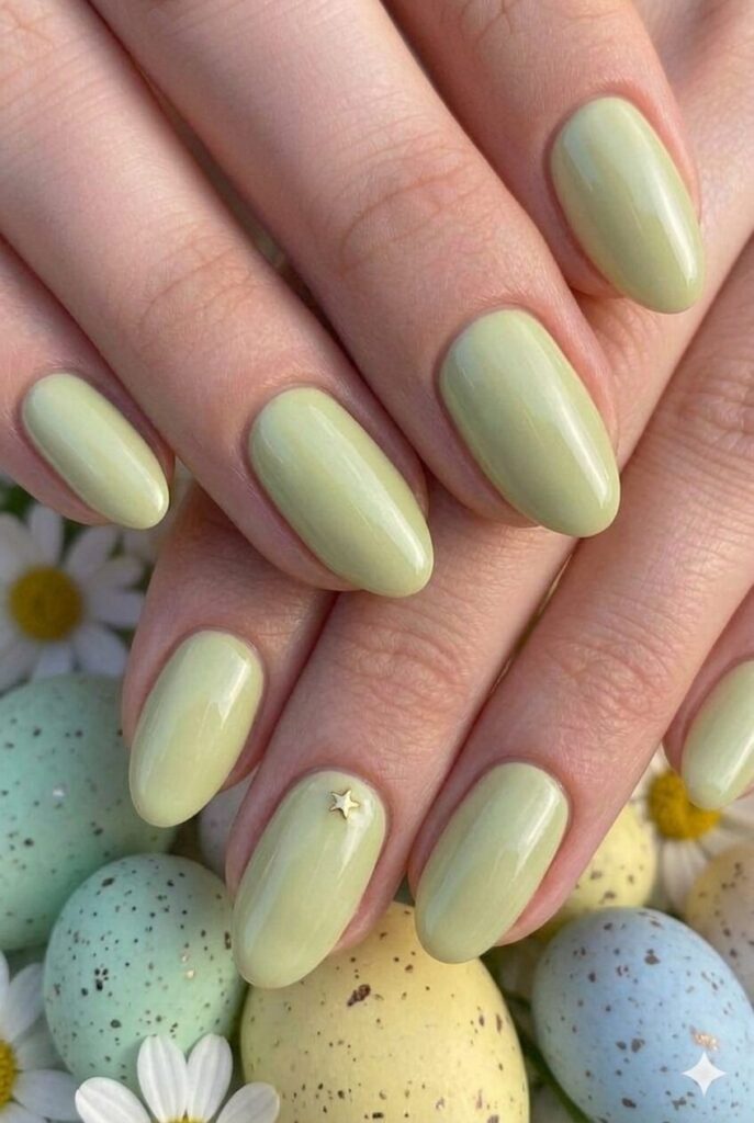 Pale pistachio pastel Easter nails with soft warm green yellow undertones, trendy fashionable manicure 2026
