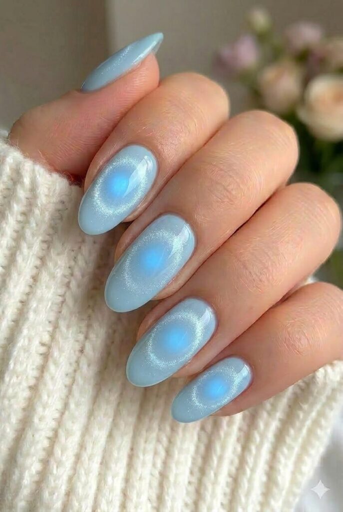 Blue halo almond prom nails with soft blue center glow on elegant almond nails