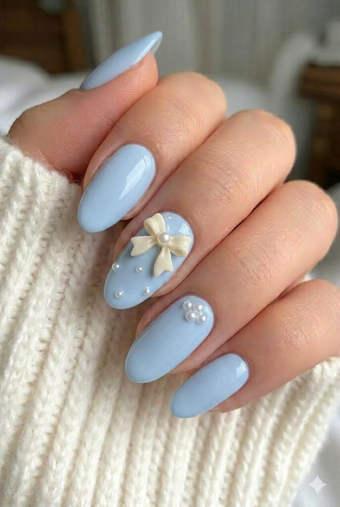 Blue pearl bow prom nails with pale blue base and tiny bow and pearl accents