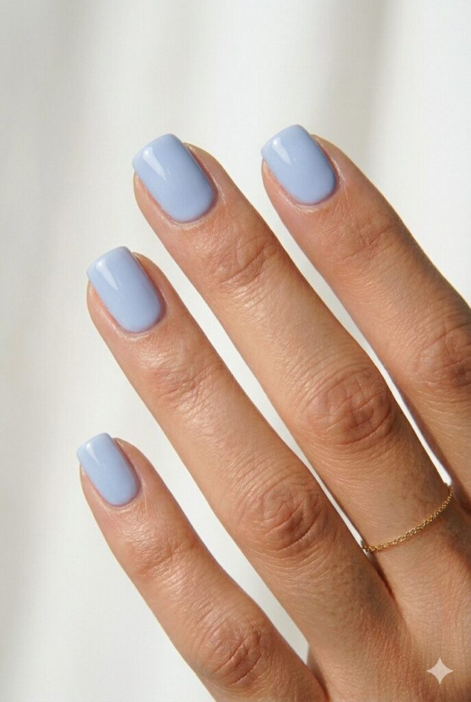 Short May nails in a creamy blueberry milk pastel blue shade with a glossy finish