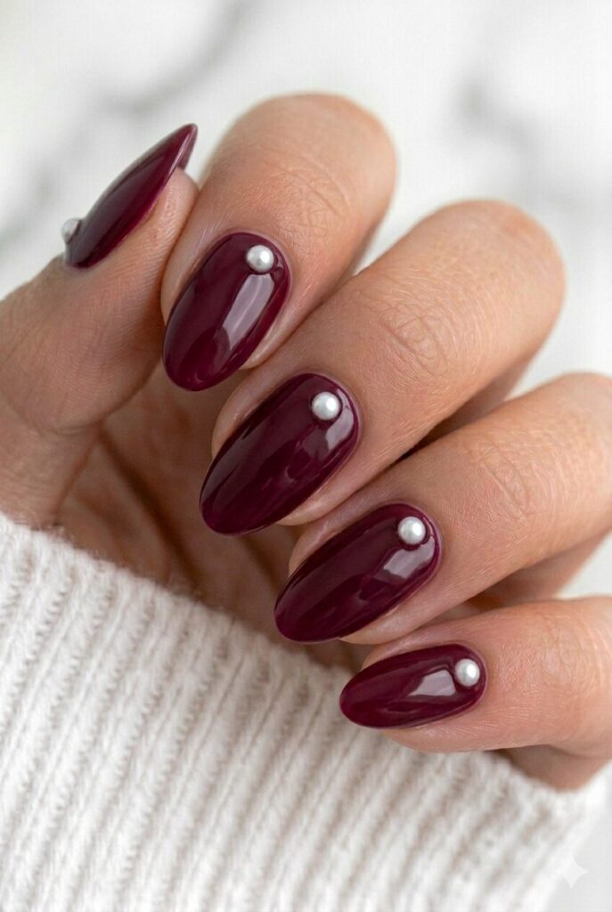 Deep burgundy graduation nails with tiny pearl accents for a rich and elegant manicure