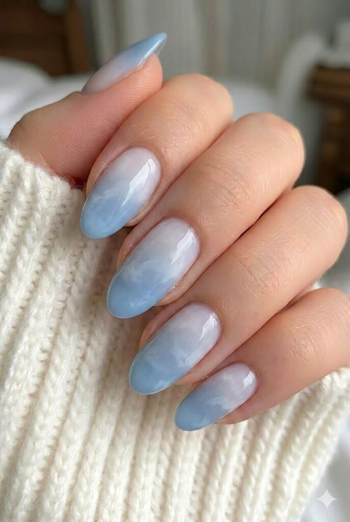 Clouded blue ombre prom nails fading from milky white into gentle cloudy blue tips