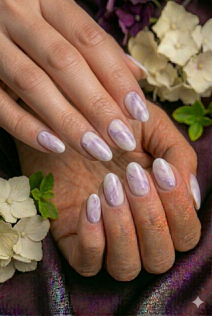 Lilac marble smoke prom nails with soft purple swirls for a trendy artistic manicure