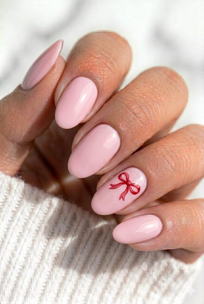 Soft pink graduation nails with a tiny diploma bow accent for a cute and feminine look