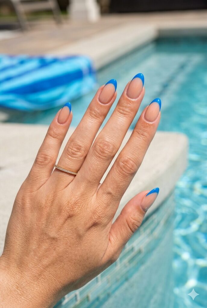 Nude nails with bright blue French tips for summer vacation