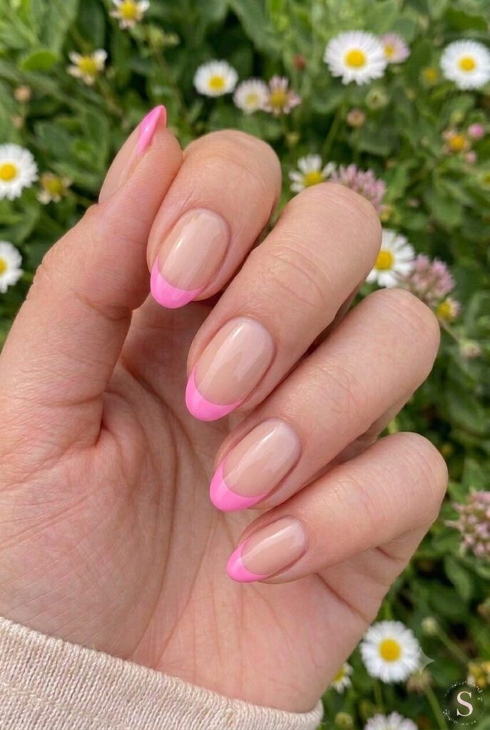 Short almond nails with nude base and bright bubblegum pink tips