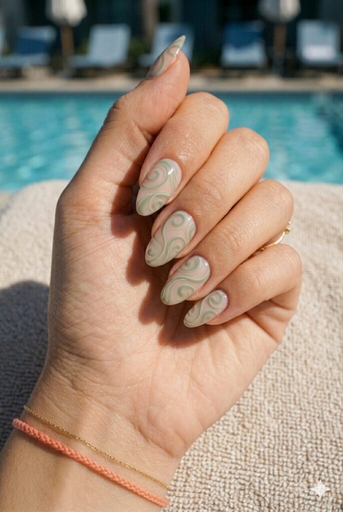 Almond nails with muted green swirl art on a sheer base