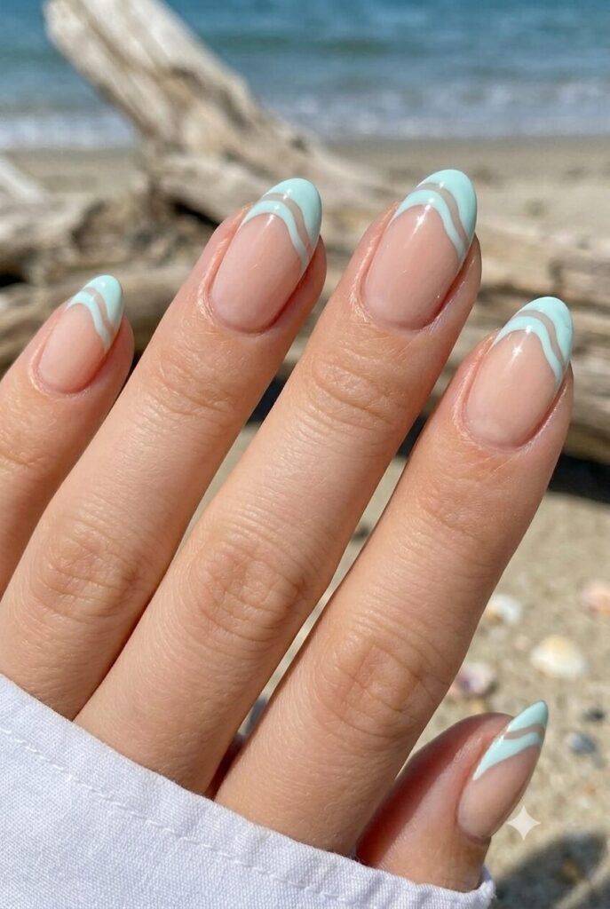 Short almond nails with nude base and pale aqua wave tips