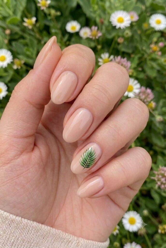 Short almond nails with nude base and tiny palm leaf accent