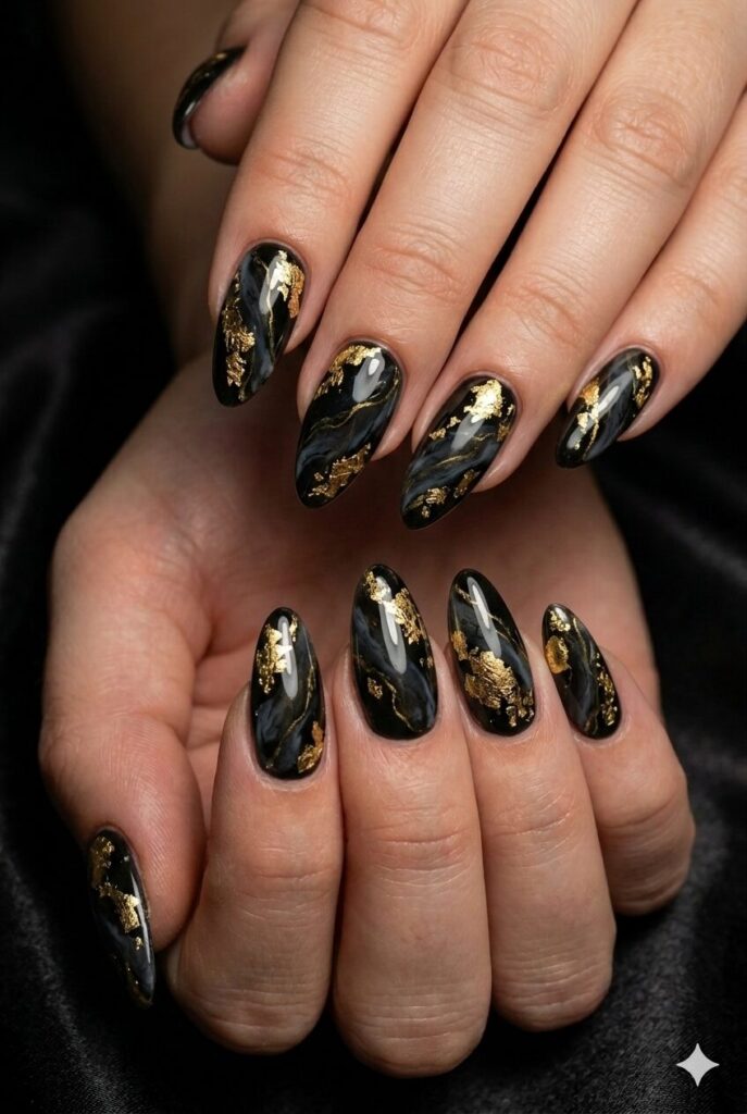 Almond nails with black polish gold foil and marble swirls