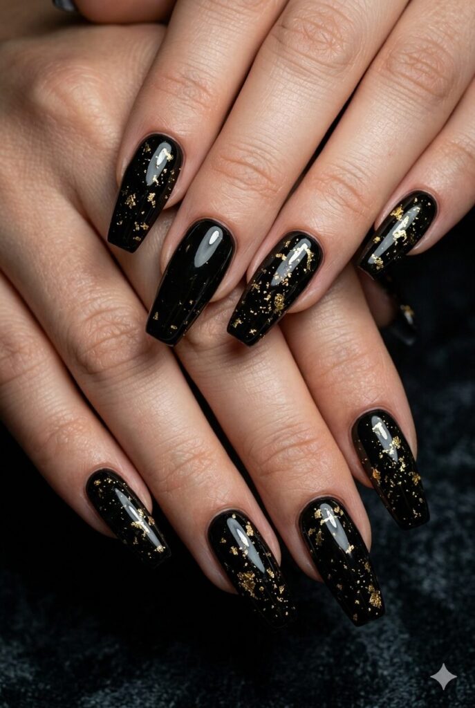 Coffin nails with glossy black base and tiny gold foil splash accents