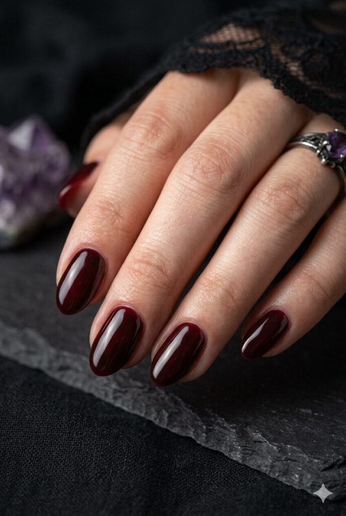 Short almond nails with glossy dark cherry red moody polish