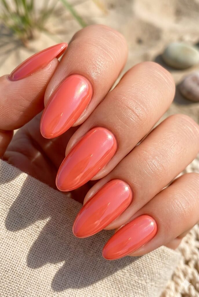 Almond oval nails with glossy coral glazed summer finish