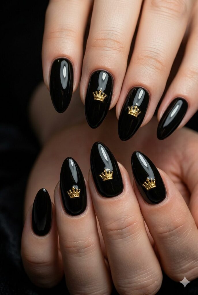 Almond nails with glossy black base and tiny gold crown accents