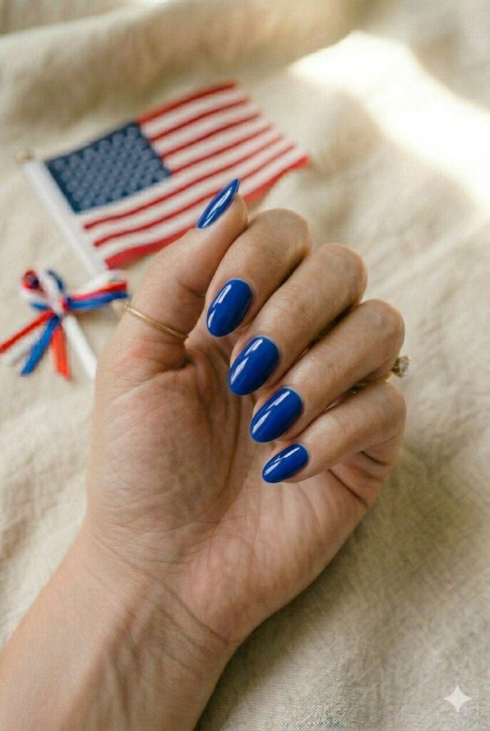 Short almond nails with glossy royal blue patriotic polish