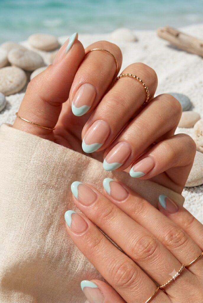 Short almond nails with nude base and pale aqua wave tips