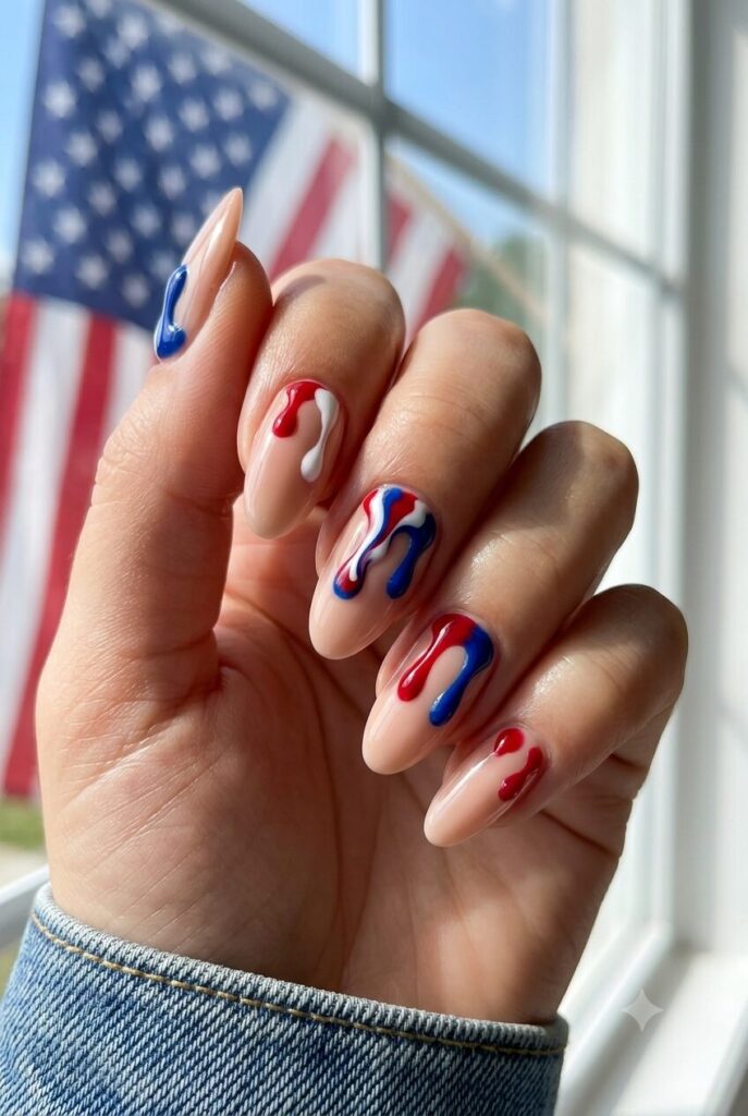 Short almond nails with nude base and red white blue drip details from cuticle
