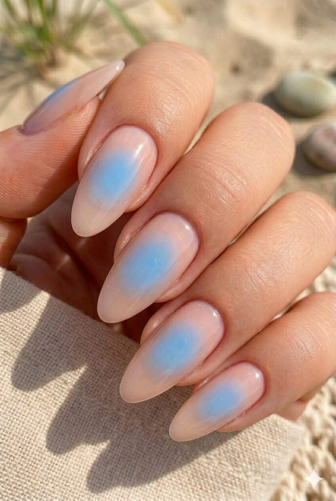 Almond nails with nude base and sky blue aura glow center