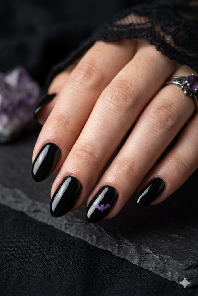 Short almond nails with black base and tiny purple bat accent