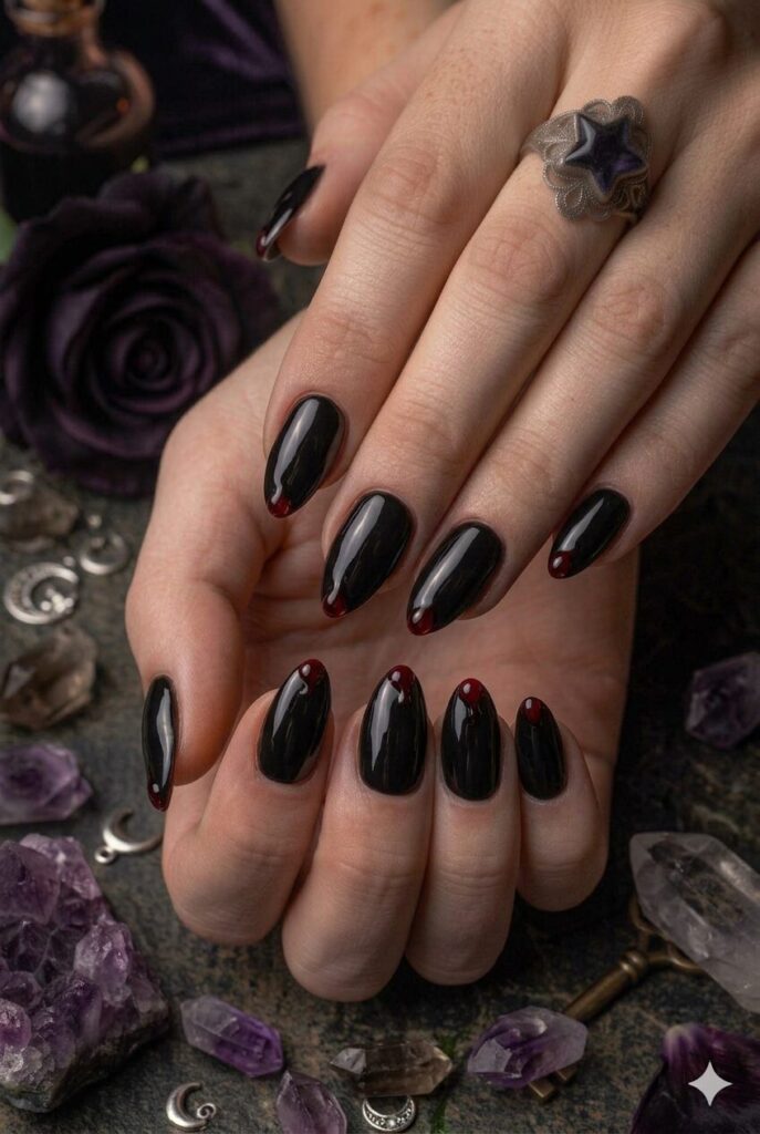 Almond nails with black polish and tiny dark cherry drip accents
