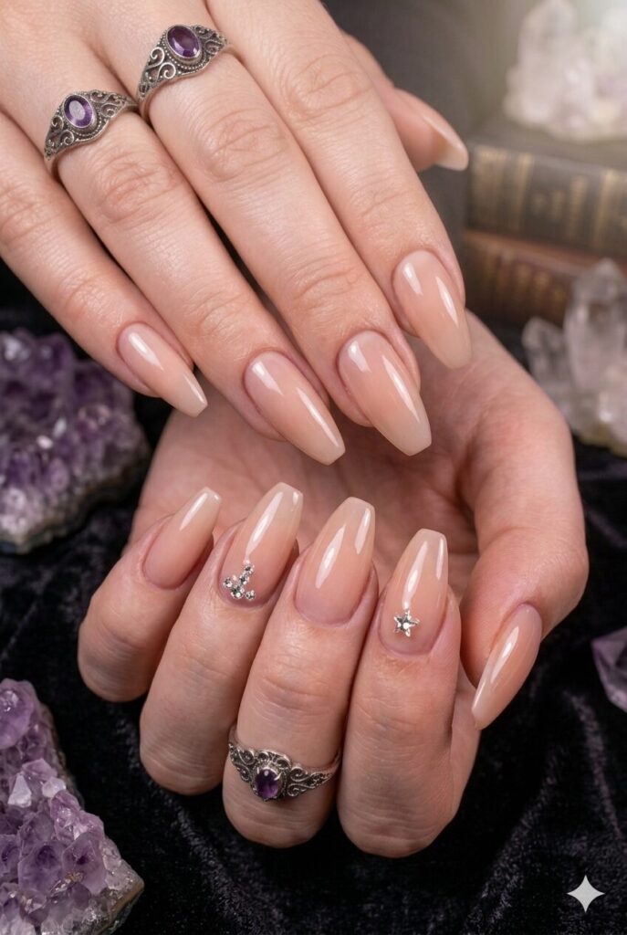 Almond nails with nude base and tiny crystal charm accents