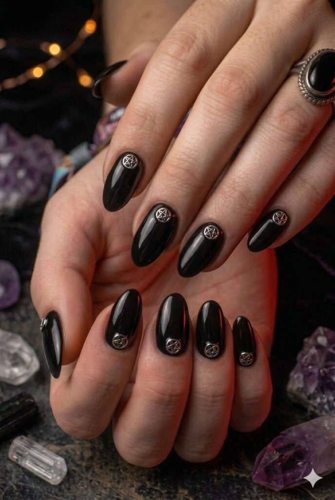 Almond nails with black base and tiny silver pentagram accents