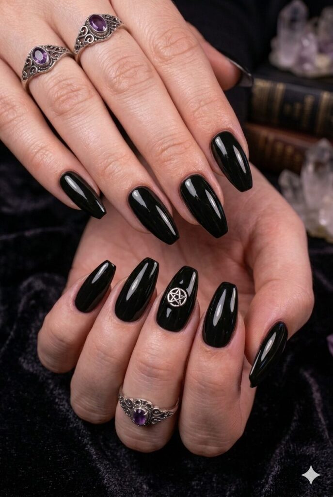 Almond nails with black base and tiny silver pentagram accent
