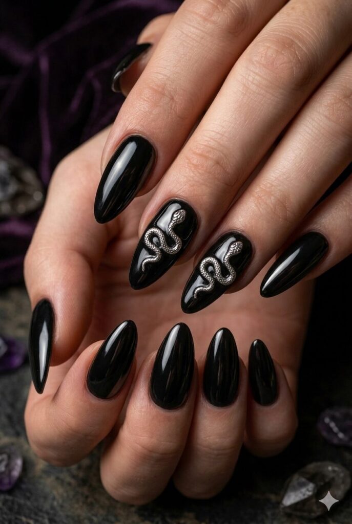 Almond nails with black polish and tiny silver snake art accents