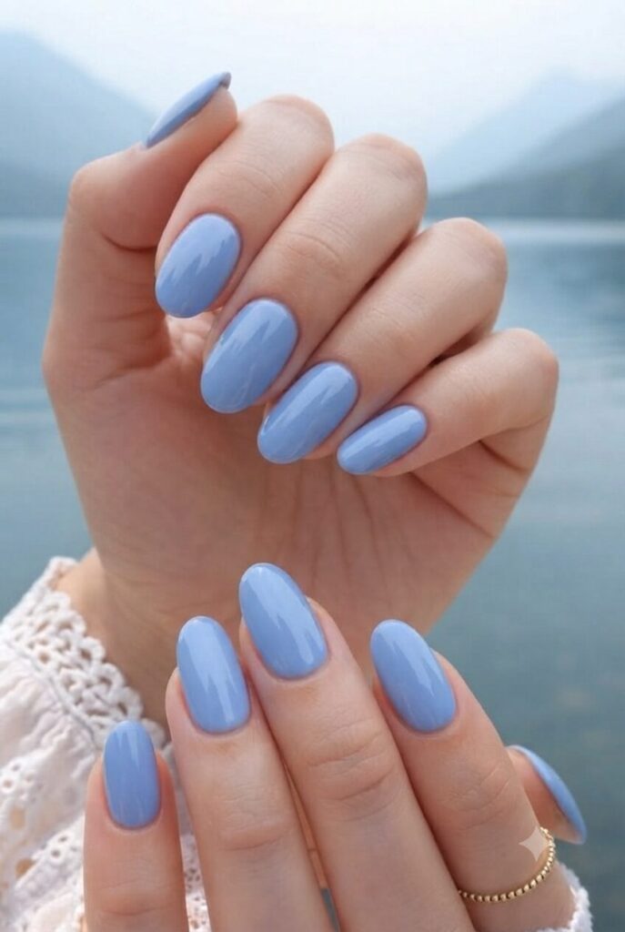 Short oval nails with glossy soft cornflower blue lake polish