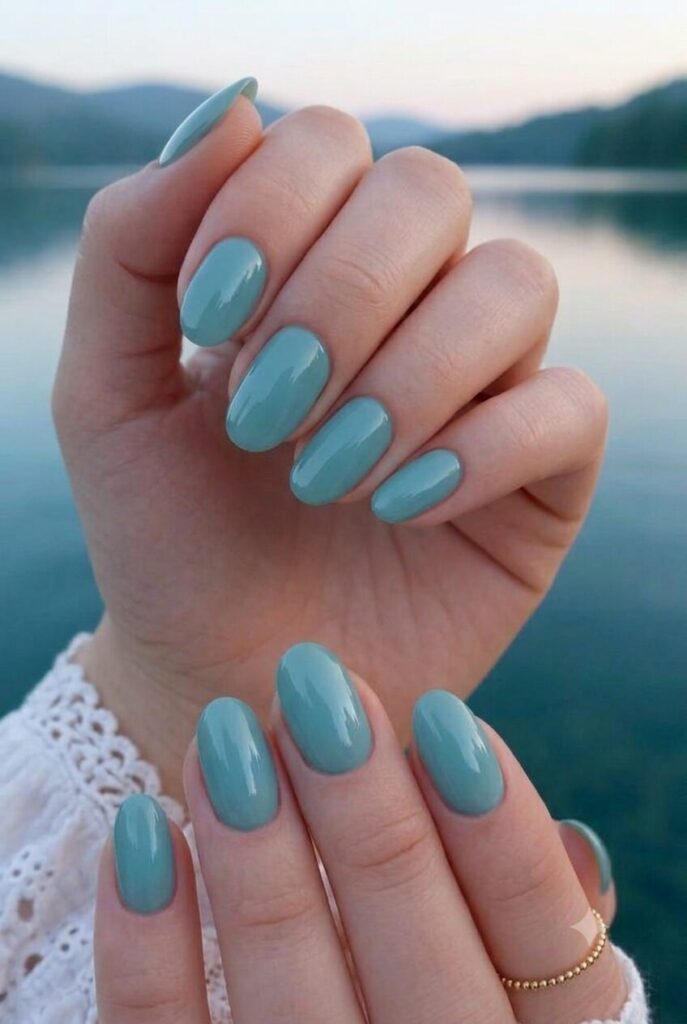Short almond nails with glossy soft teal lake-inspired polish