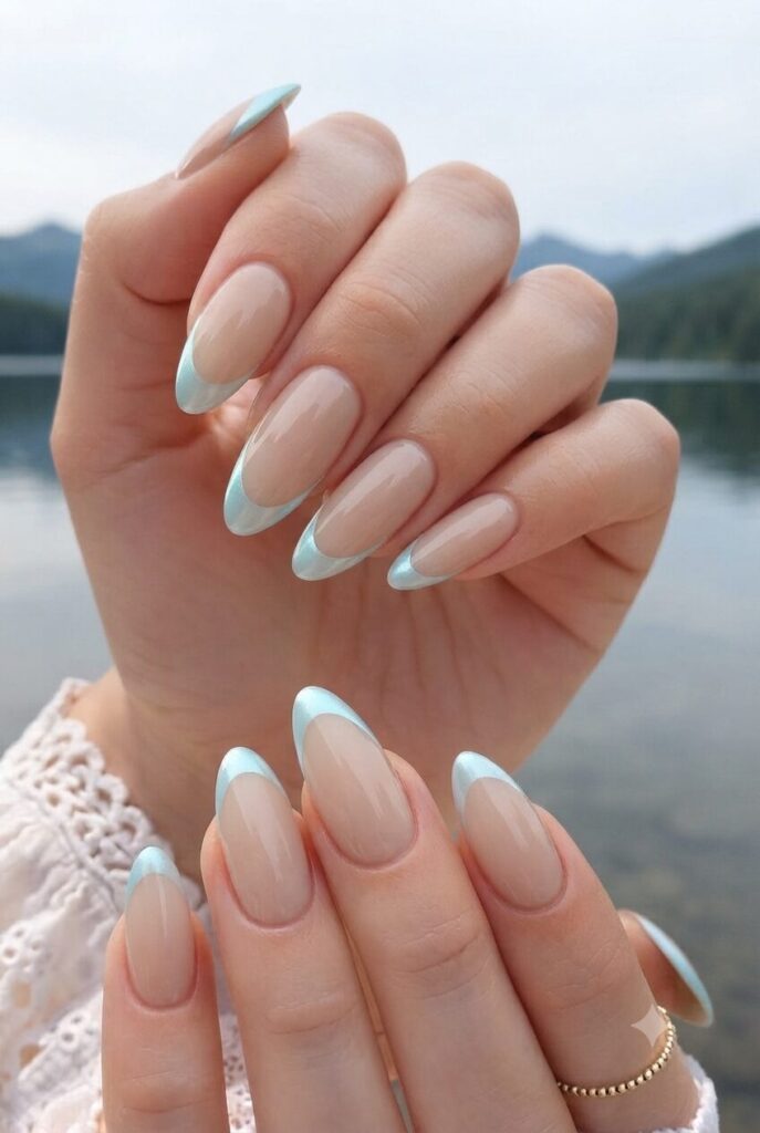 Short almond nails with nude base and soft pearl aqua French tips