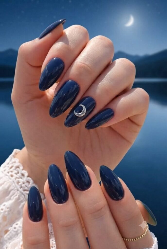 Short almond nails with navy base and tiny silver crescent moon accent