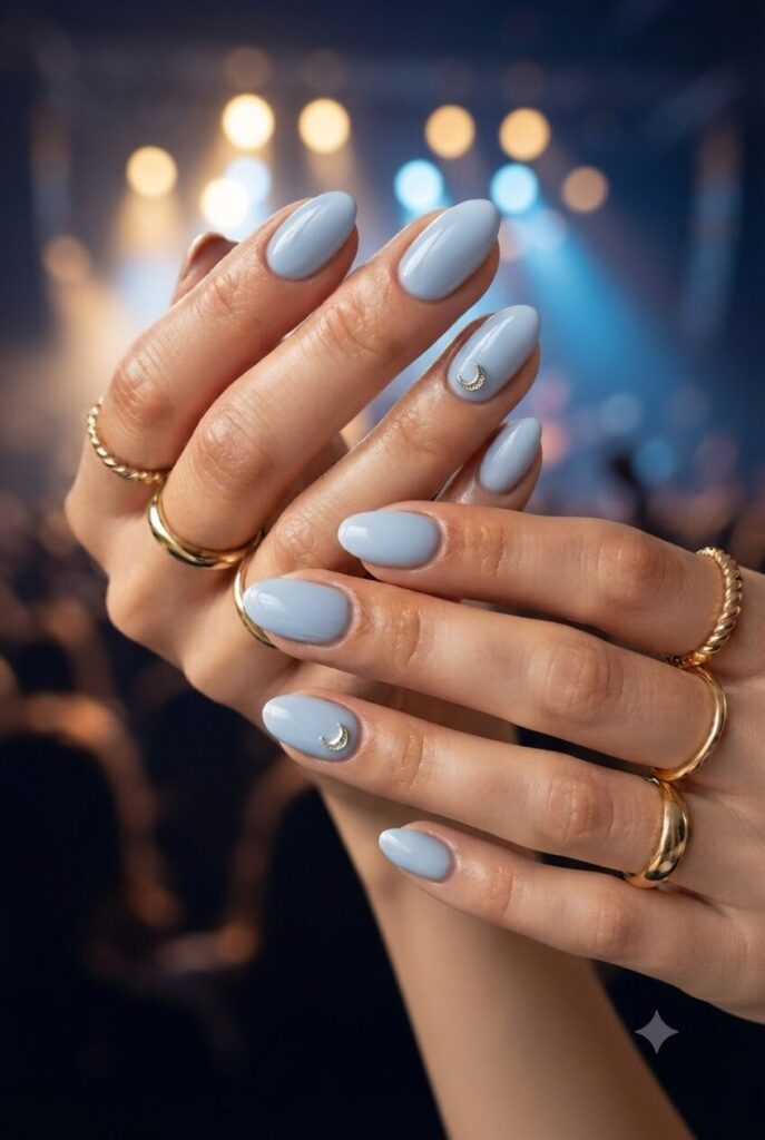 Short oval nails with blue base and tiny silver crescent moon accents