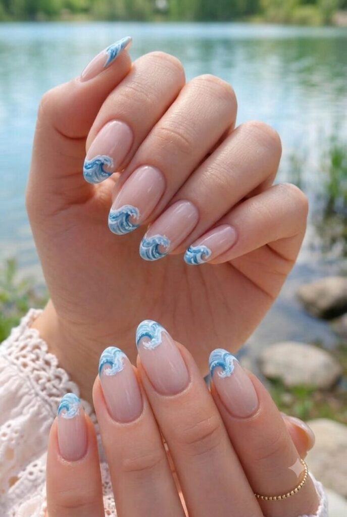 Short almond nails with nude base and tiny blue wave ripple accents