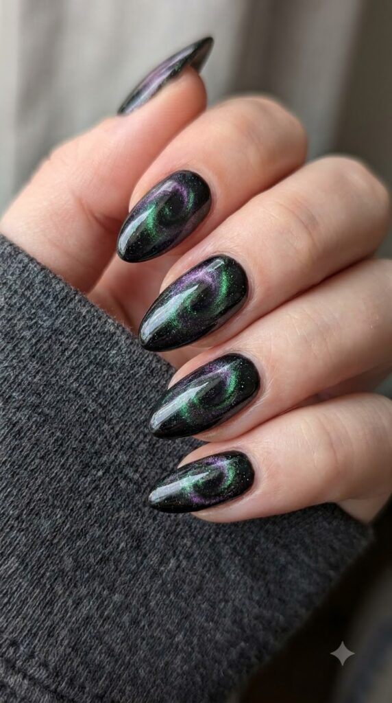 Almond black magnetic cat-eye nails swirled with emerald and purple