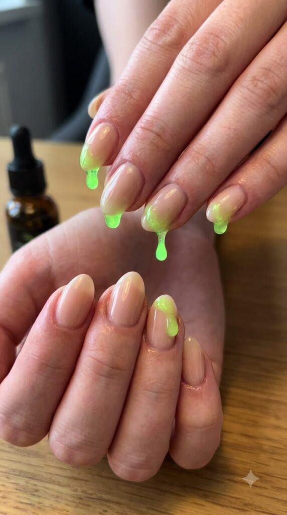 Short almond nude nails with glowing neon green potion drip tips