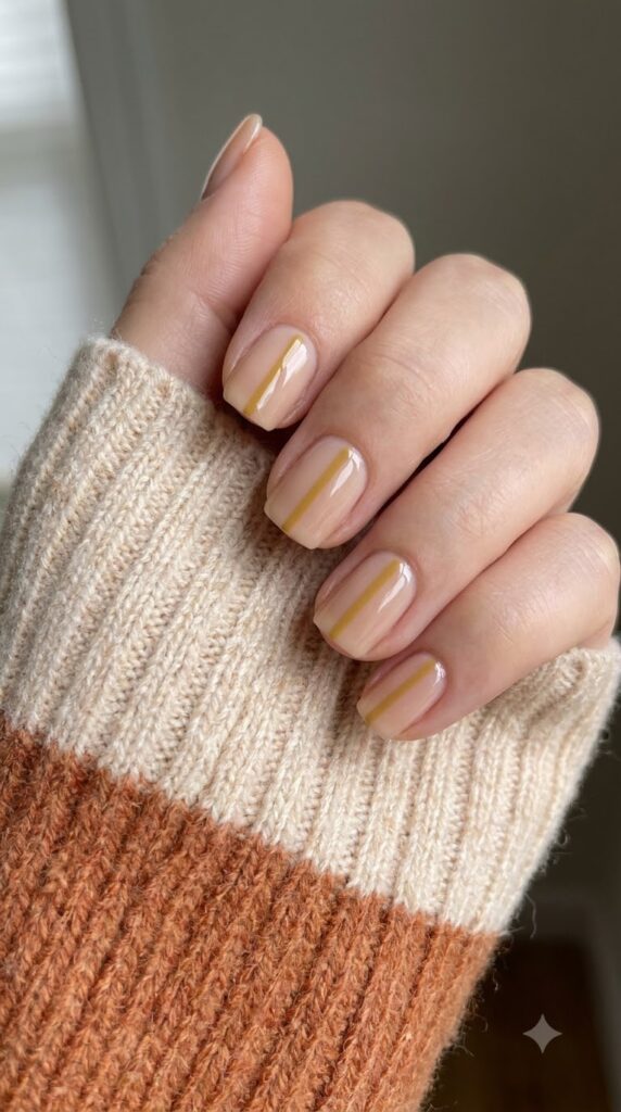 Short square nails with nude base and vertical mustard yellow line