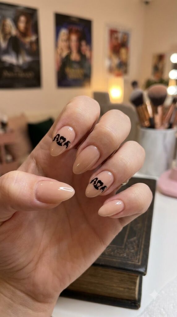 Medium almond nude nails with black Sanderson sister silhouettes