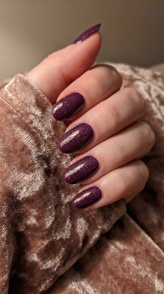 Oval deep plum purple nails with gold micro-shimmer sparkle