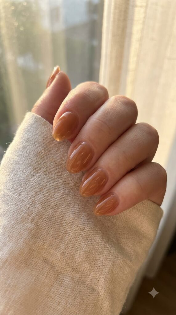 Short almond nails with sheer caramel glaze polish