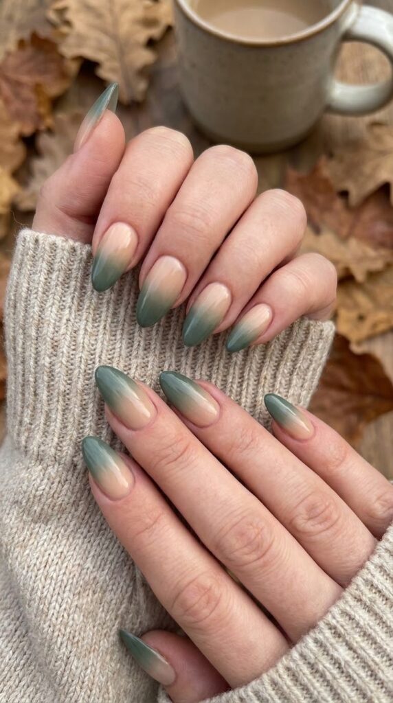 Almond nails with nude base fading into deep sage green tips