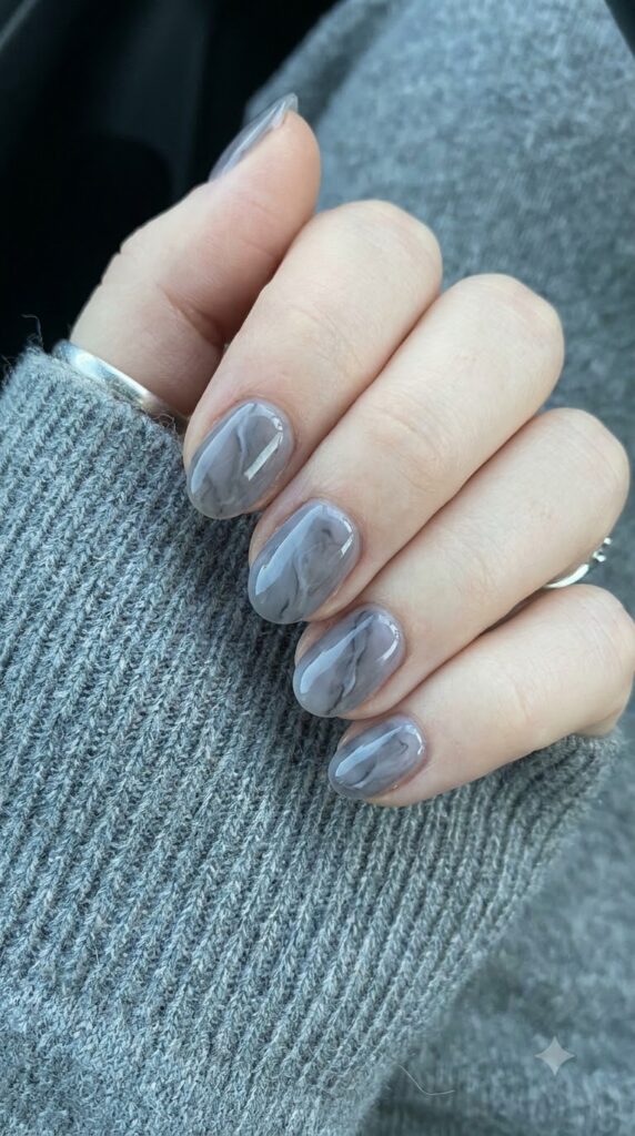 Short oval smoky grey nails with white charcoal fog marble veins