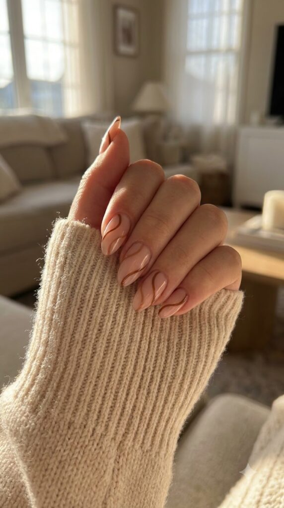 Almond nails with nude base and toasted almond brown swirls