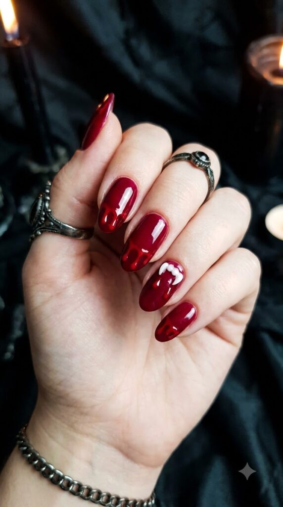 Oval red nails with dripping blood and vampire fang marks