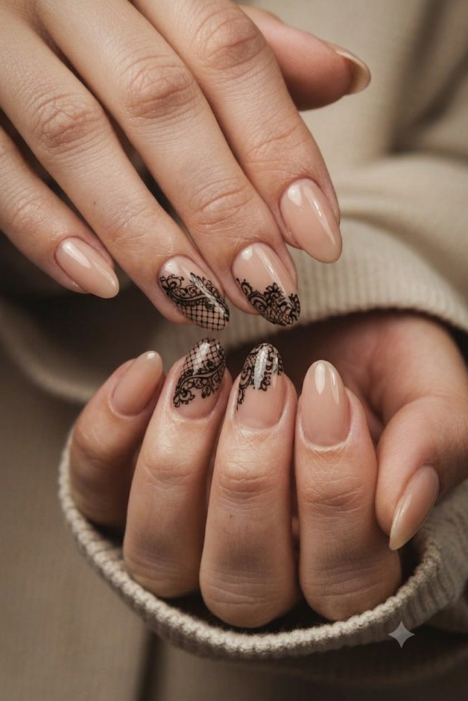 Short almond nails with sheer nude and delicate black Victorian lace