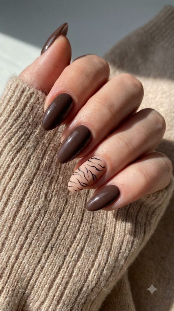 Almond mocha brown gel nails with a nude accent nail featuring tiger stripes